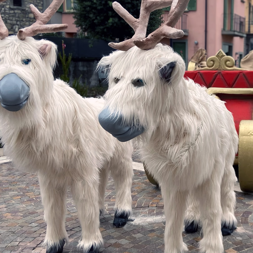 Installazione scenografica "Chi Ha Incastrato Santa Claus" con renne realistiche animate, slitta ornata e igloo scenico in piazza storica, creando esperienza natalizia immersiva per eventi urbani.