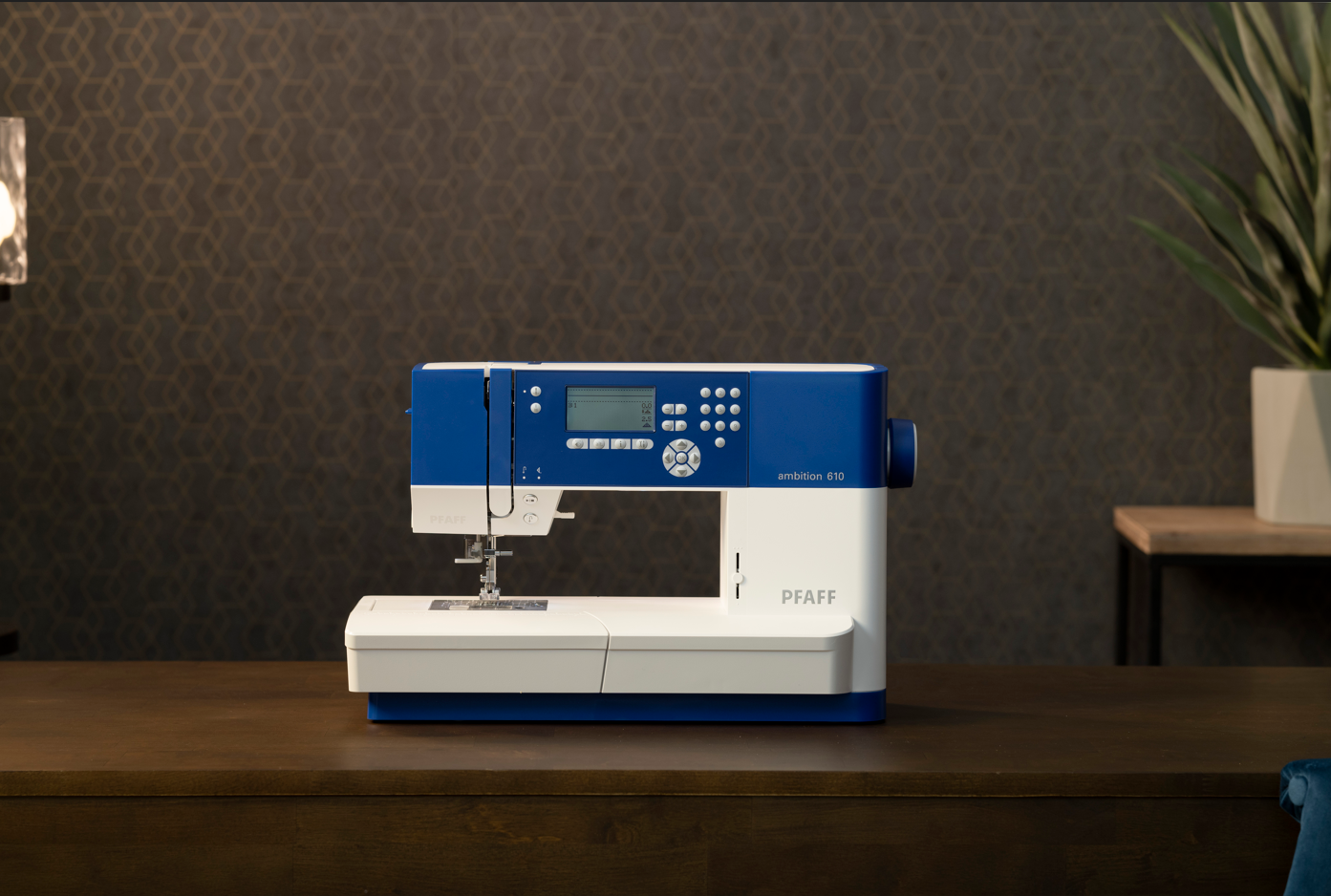 Machine à coudre Pfaff Ambition 610 bleue et blanche sur une table en bois.