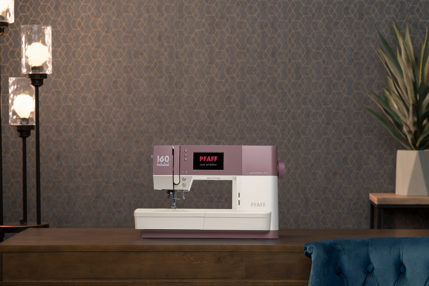 Machine à coudre PFAFF Quilt Ambition 635 rose et blanche sur une table en bois devant un mur décoré.