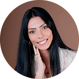 Fotografia de Joana Afonseca, gerente e administradora da MHArquitetos. Uma mulher de cabelo escuro comprido e de sorriso rasgado.