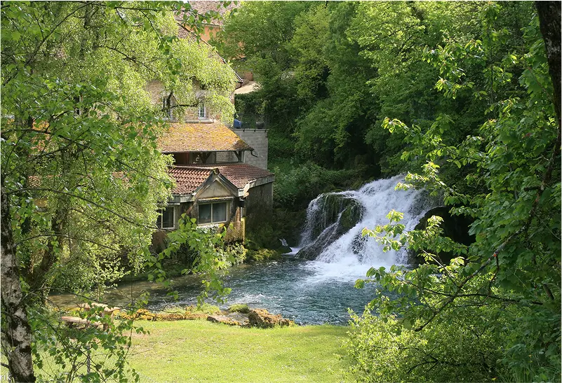 Huis in de natuur met een waterval ernaast