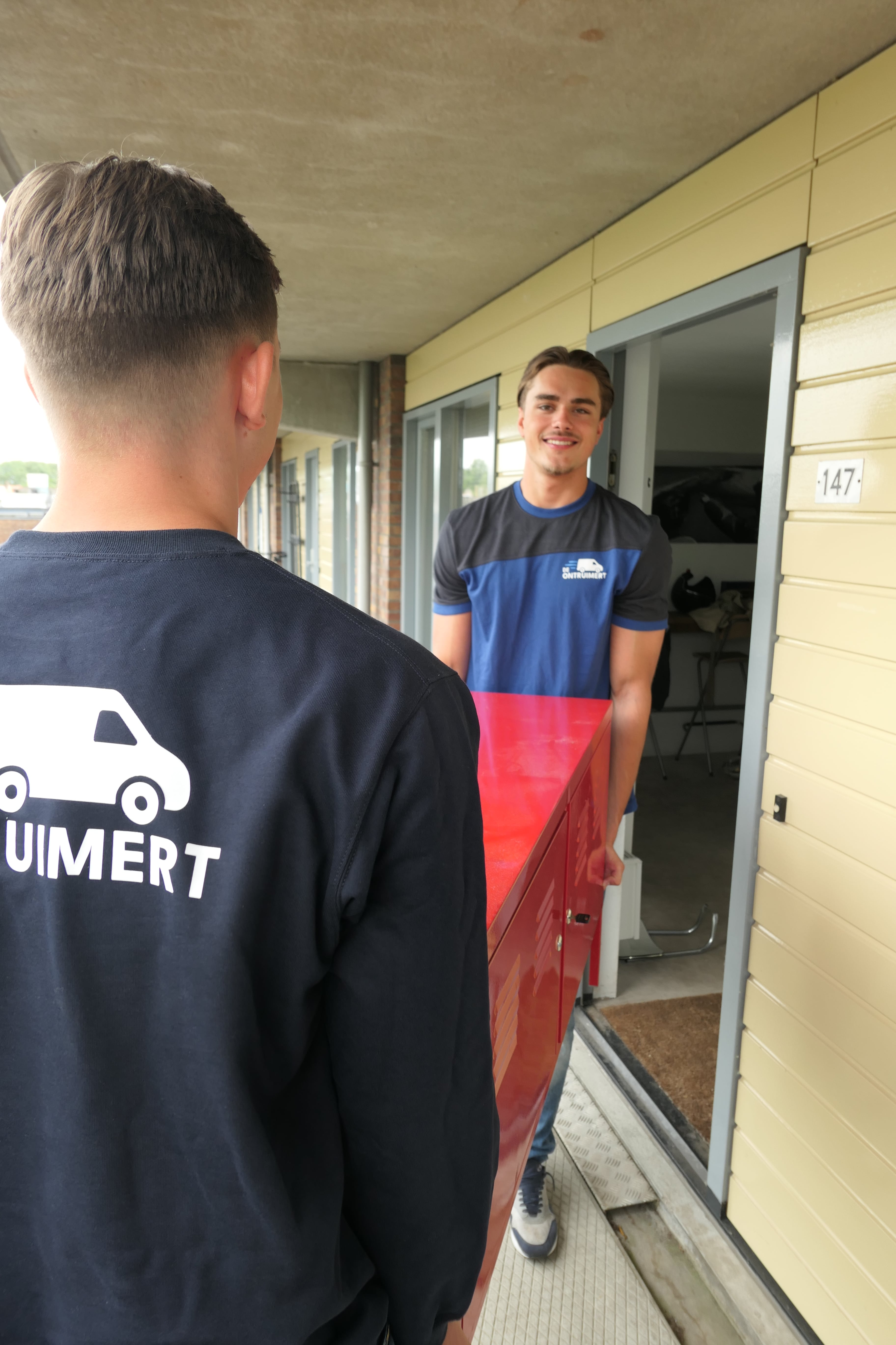 Twee ontruimers dragen een rode kast