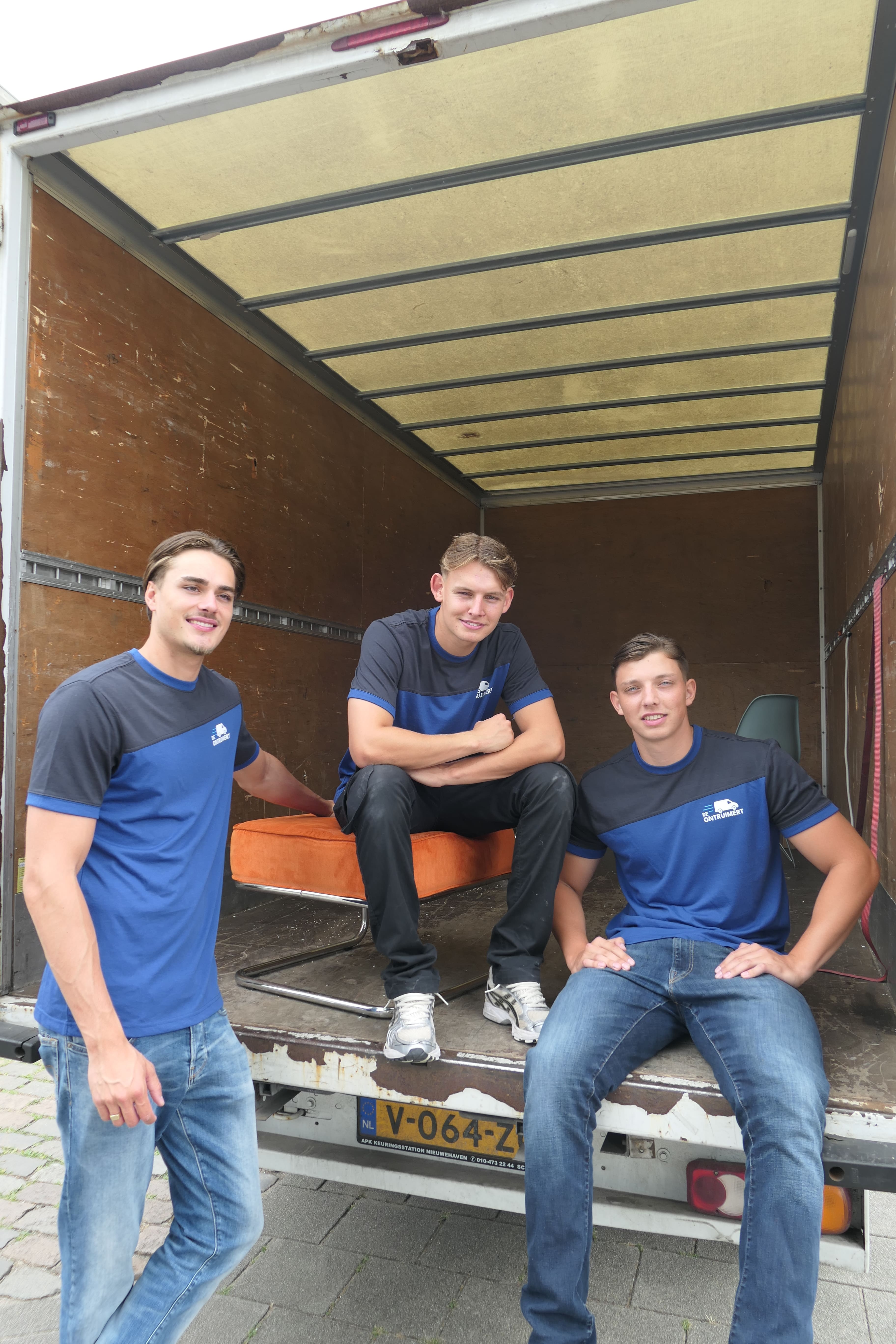 Drie ontruimers in het ruim van een werkbus