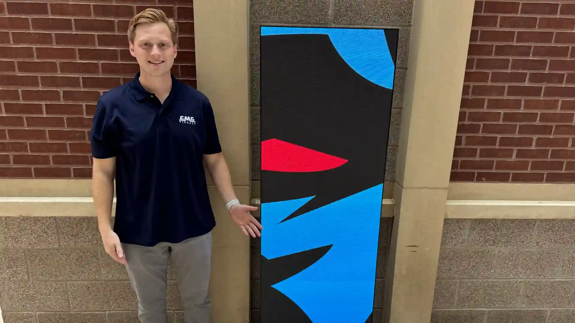 Jack standing in front of CMG Visuals LED poster.