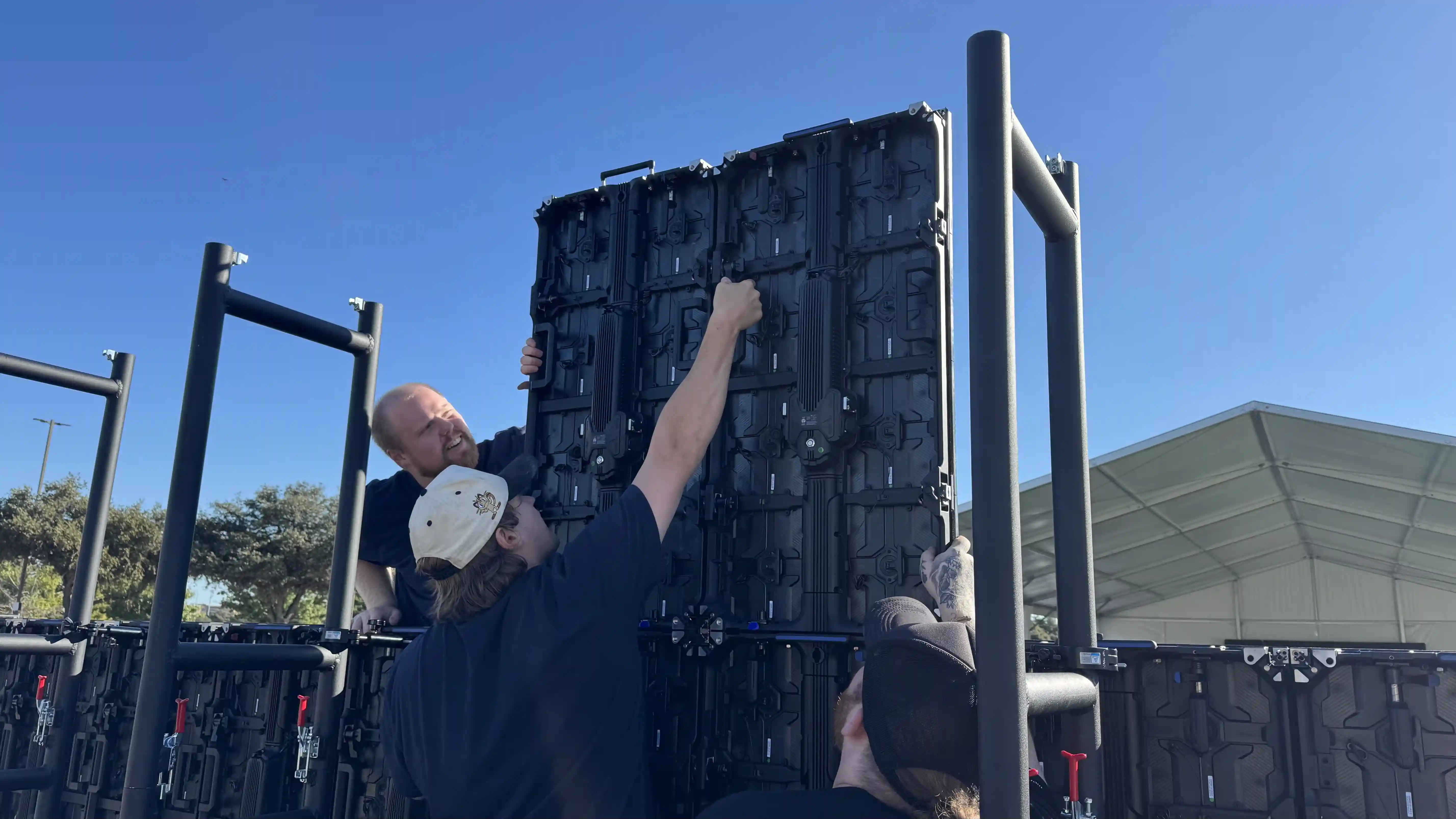Outdoor LED video wall installation in Austin Texas with technicians mounting panels