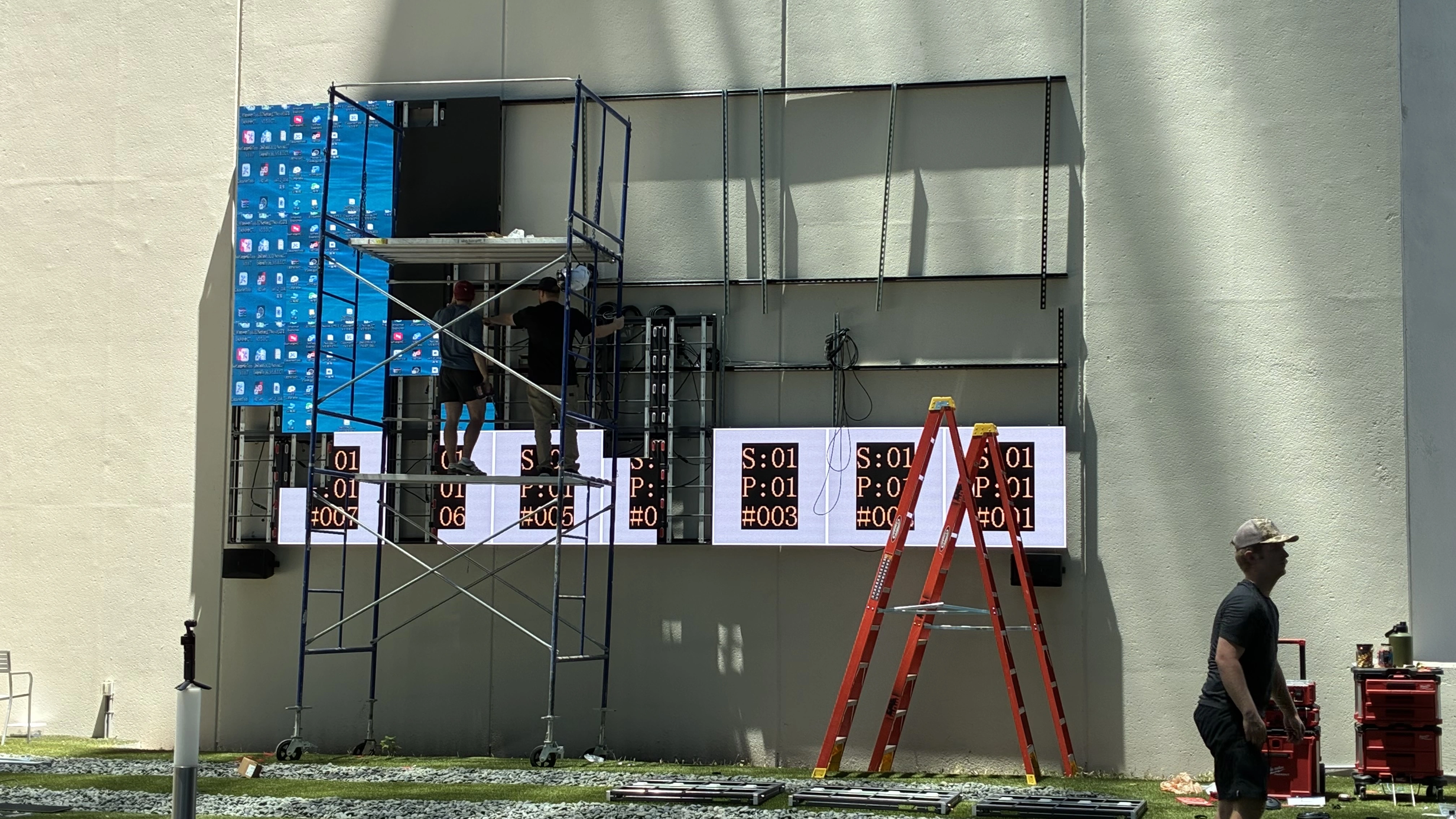 CMG Visuals technicians installing and testing outdoor LED panels at UrbanTowers