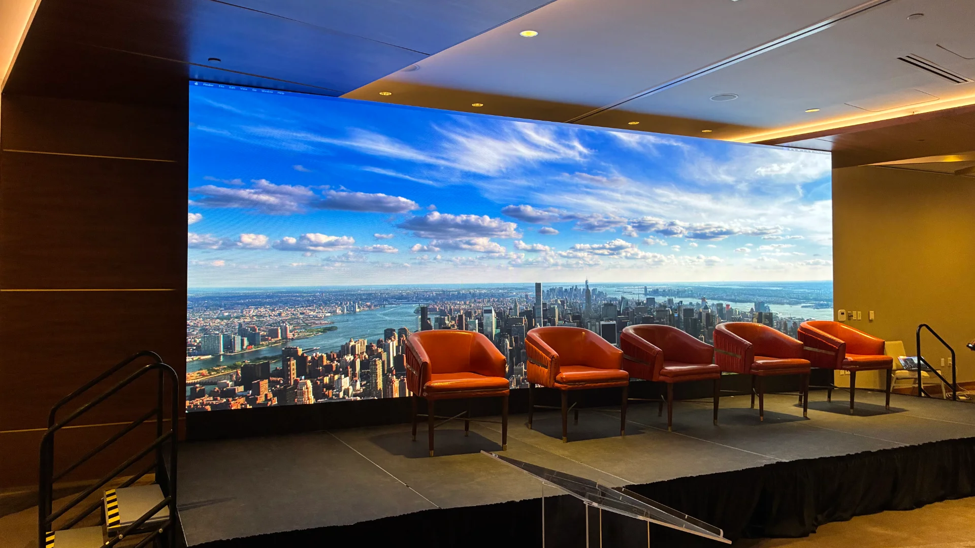 Stage LED video wall showing city skyline behind panel chairs