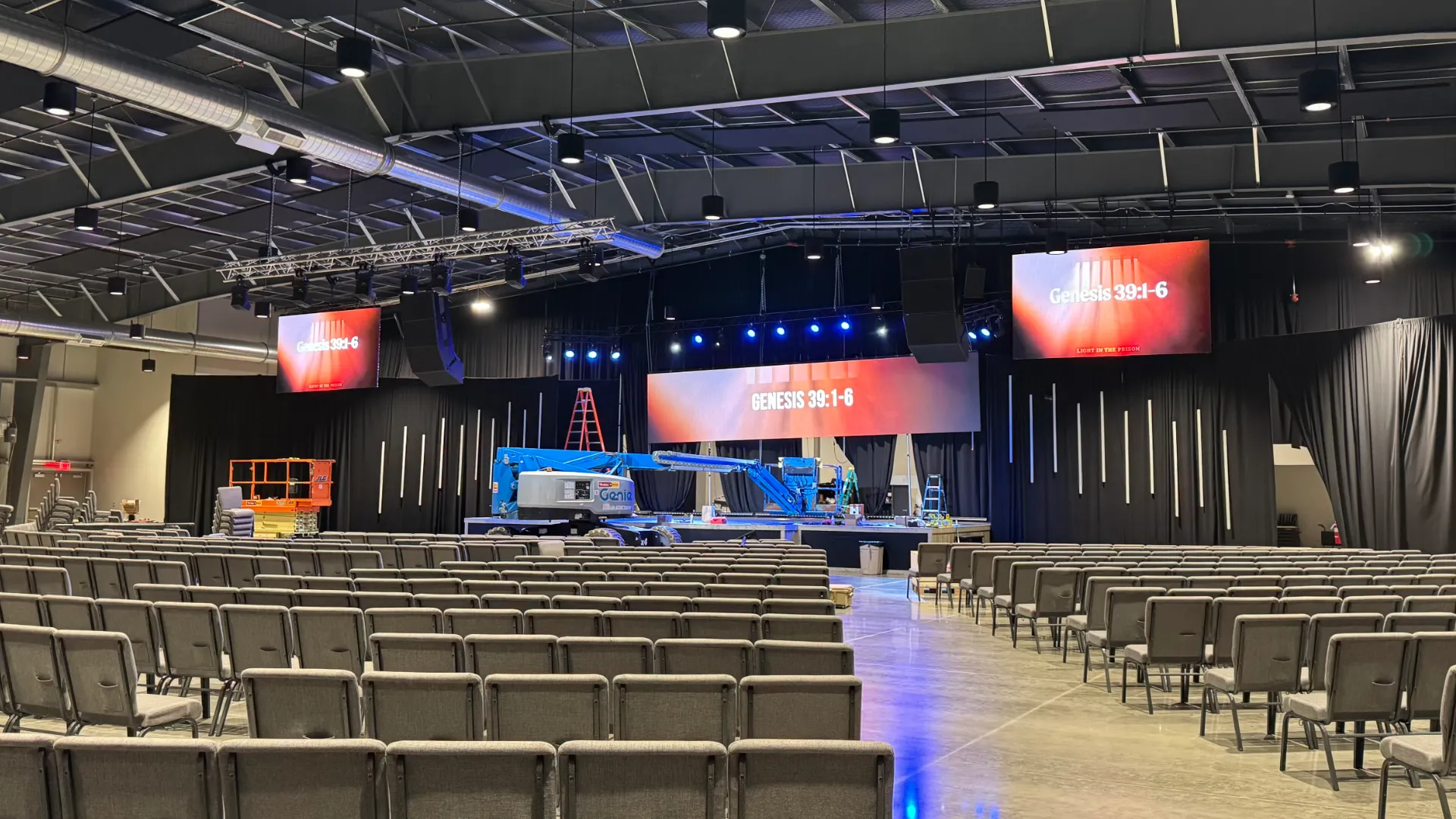 Church auditorium with three LED stage screens during install