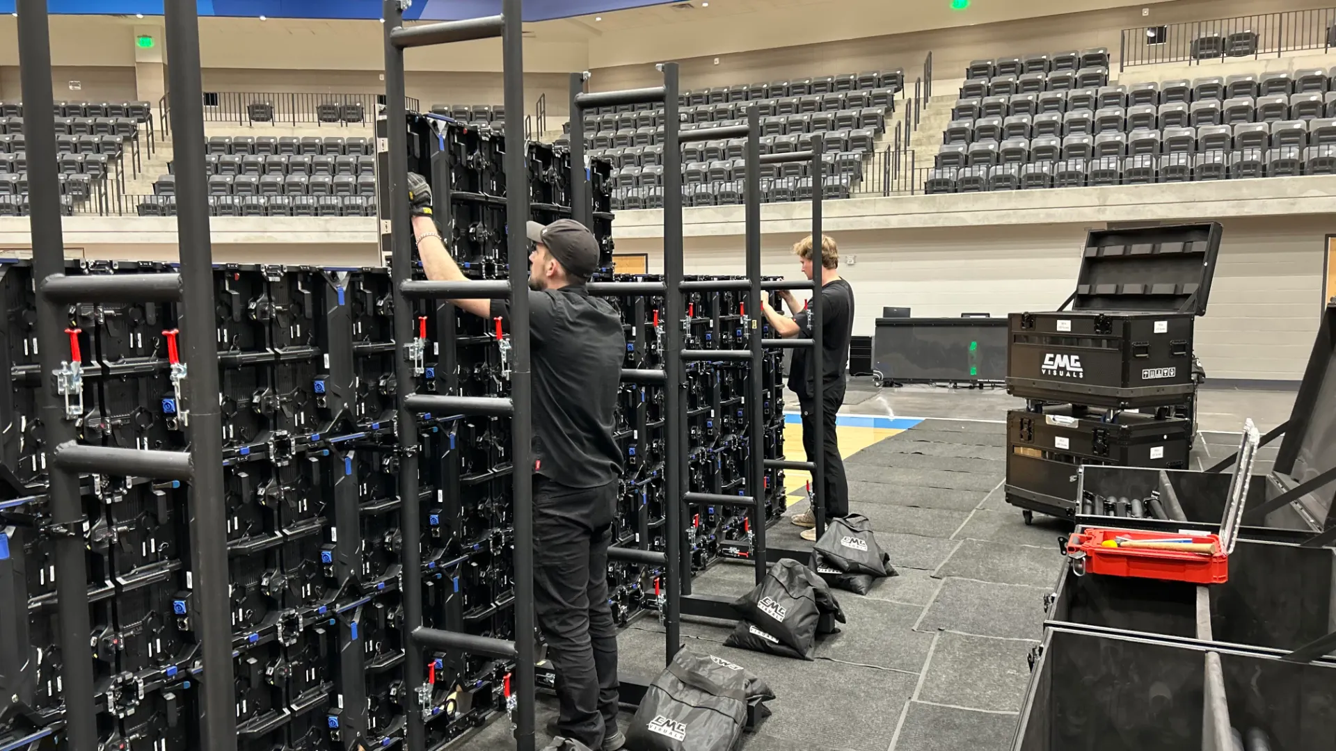 CMG Visuals technicians building the BetMGM LED video wall panel by panel on rolling racks.