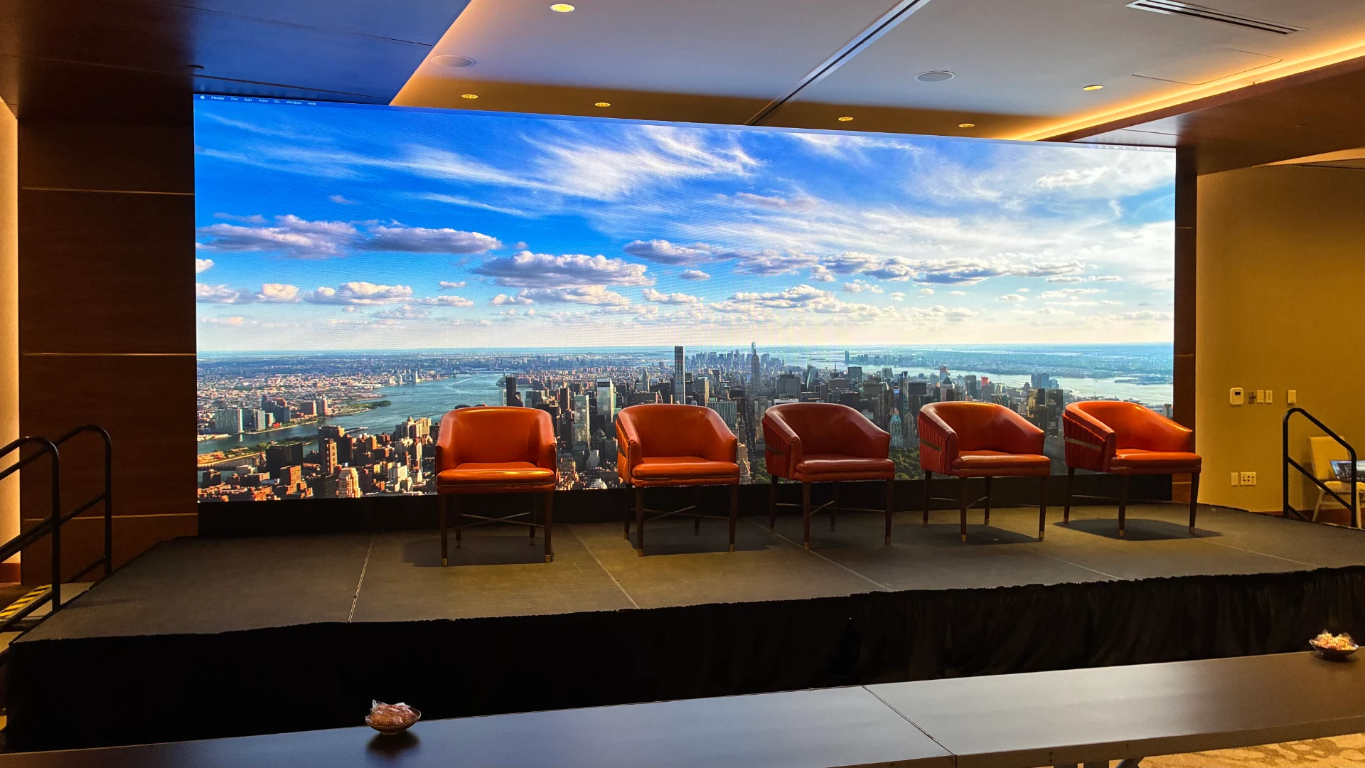 Indoor CMG Visuals LED wall showing a New York skyline behind a panel stage setup at The Statler Dallas.