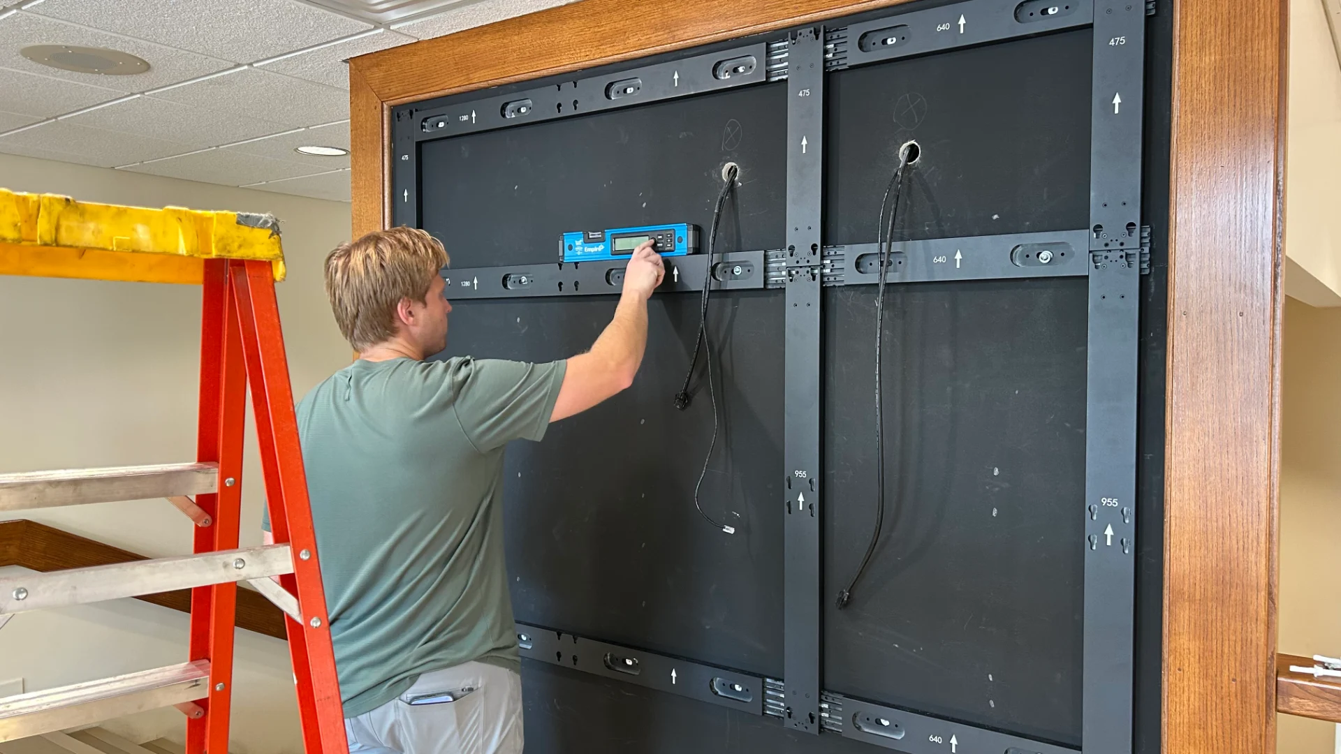 CMG Visuals technician leveling the mounting frame while installing the LED wall at Pellissippi State Community College.
