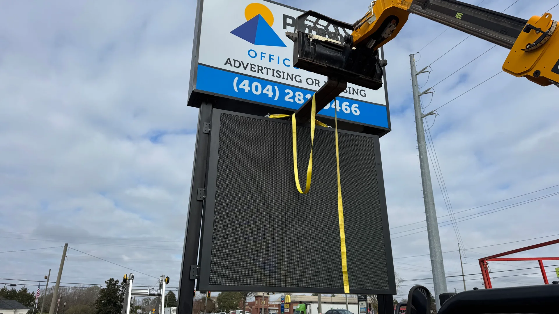 Crew lifting the LED display into the Pyramid Point pylon sign during a CMG Visuals outdoor installation.