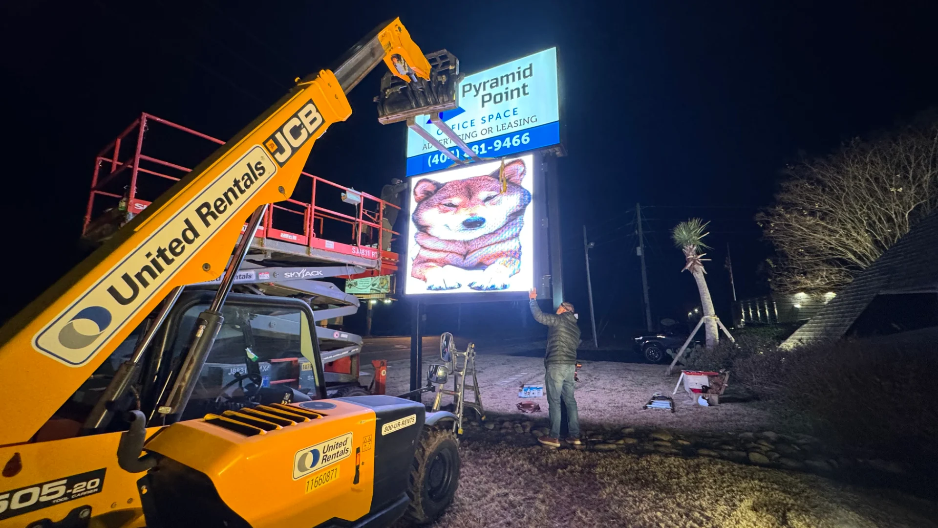 CMG Visuals technician installing the outdoor LED sign at Pyramid Point at night during a power on test.