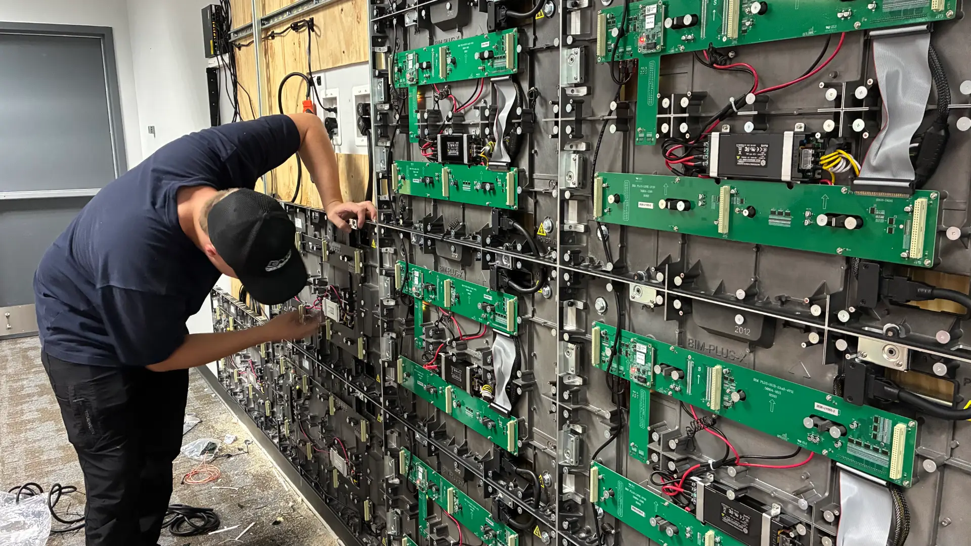 CMG Visuals technician wiring the indoor LED wall panels