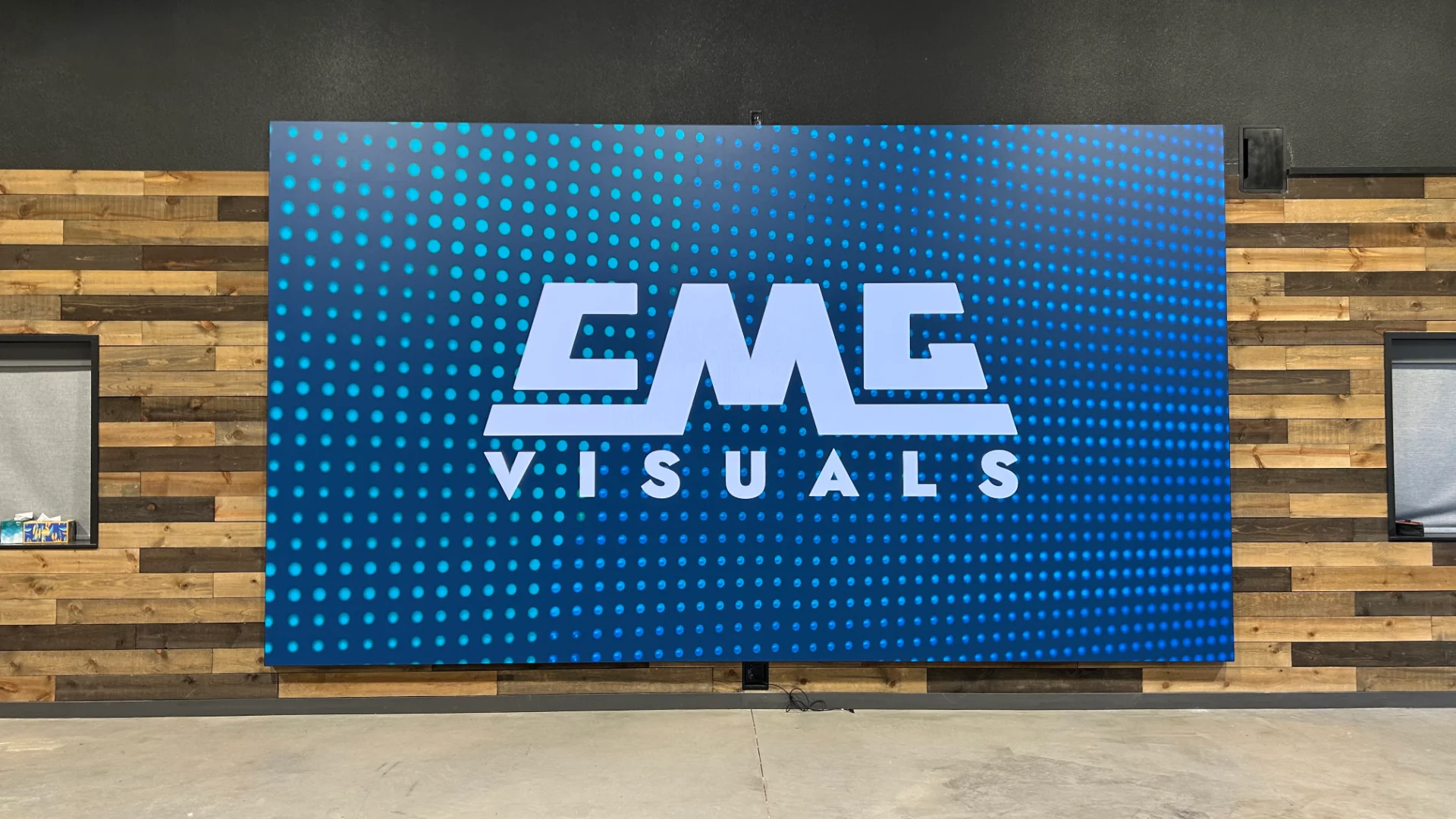 CMG Visuals indoor LED video wall lit up on a wood accent wall.