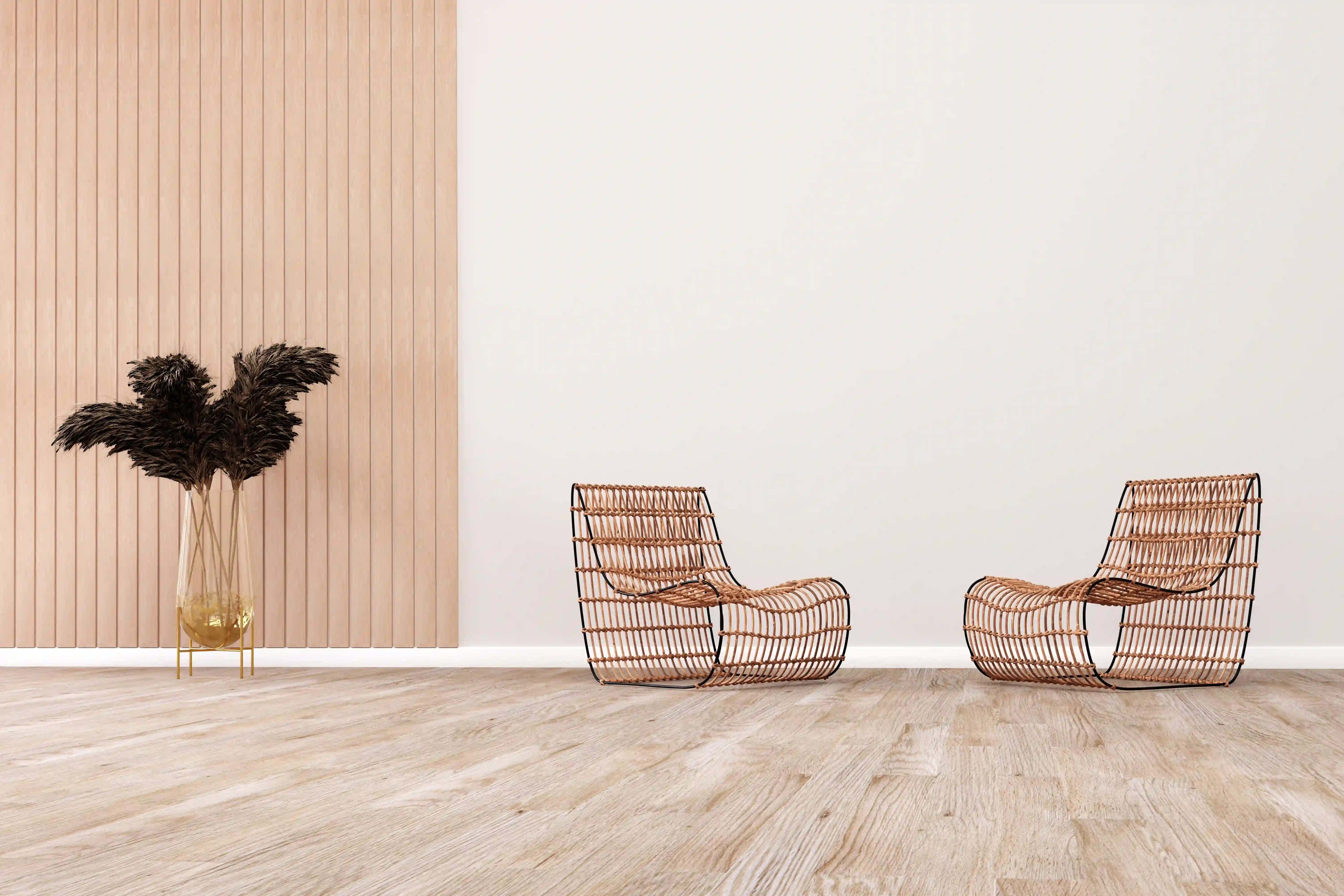 Minimalist interior with two rattan lounge chairs and a tall vase of dried foliage
