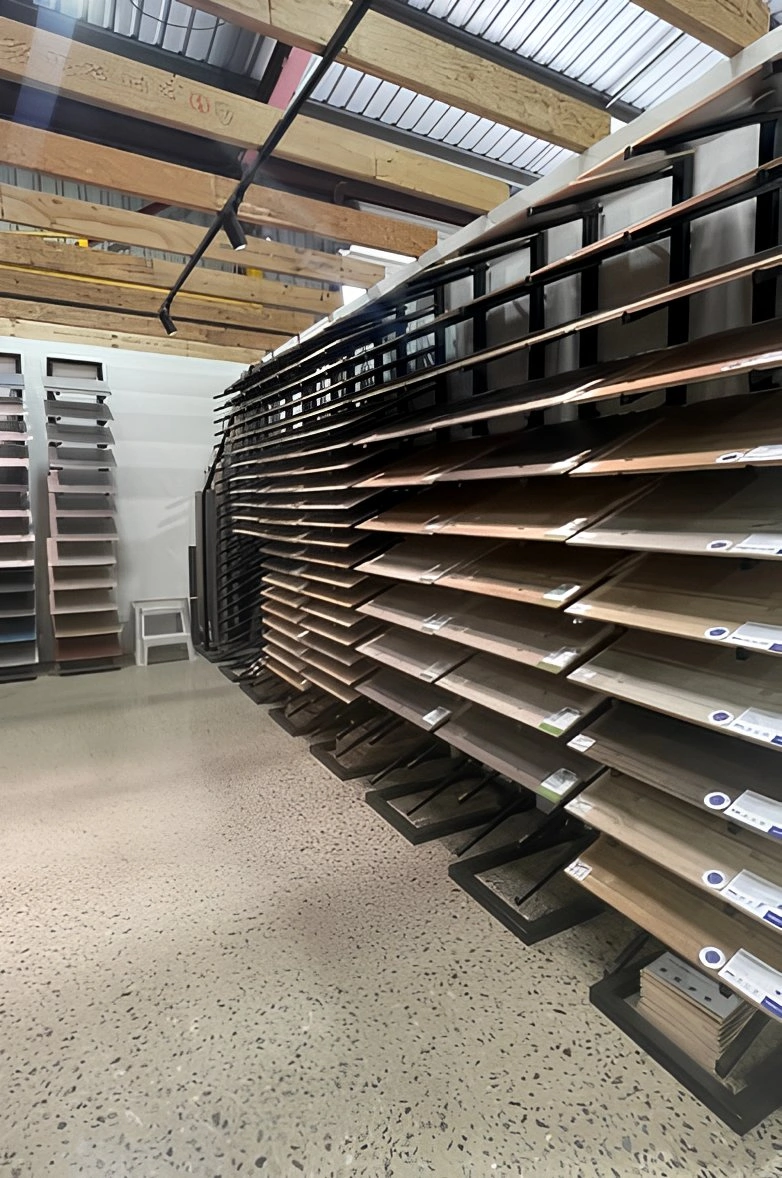 Showroom display racks filled with wood and laminate flooring samples in various shades
