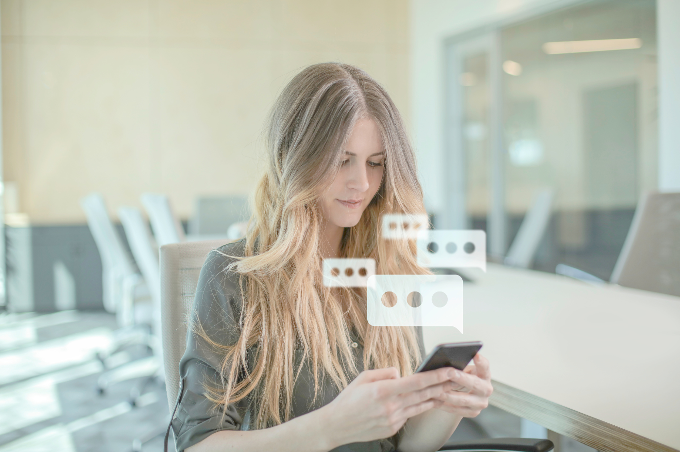 Woman texting with animated text bubbles popping out of her cell phone
