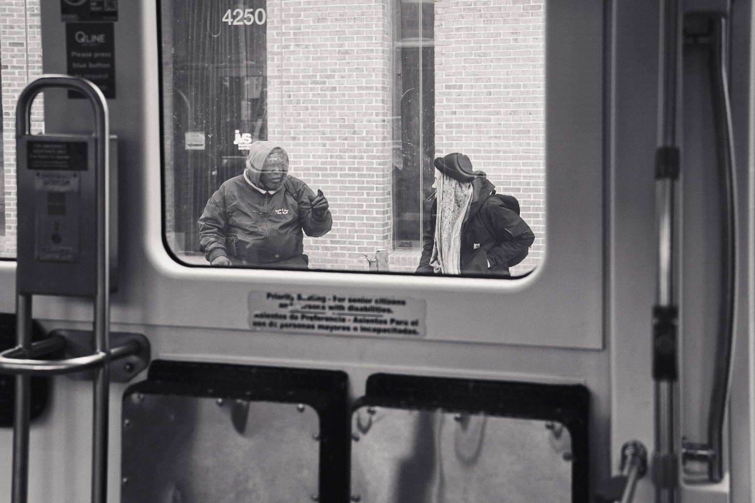 Street photography of two gentlemen talking at Downtown Detroit tram stop