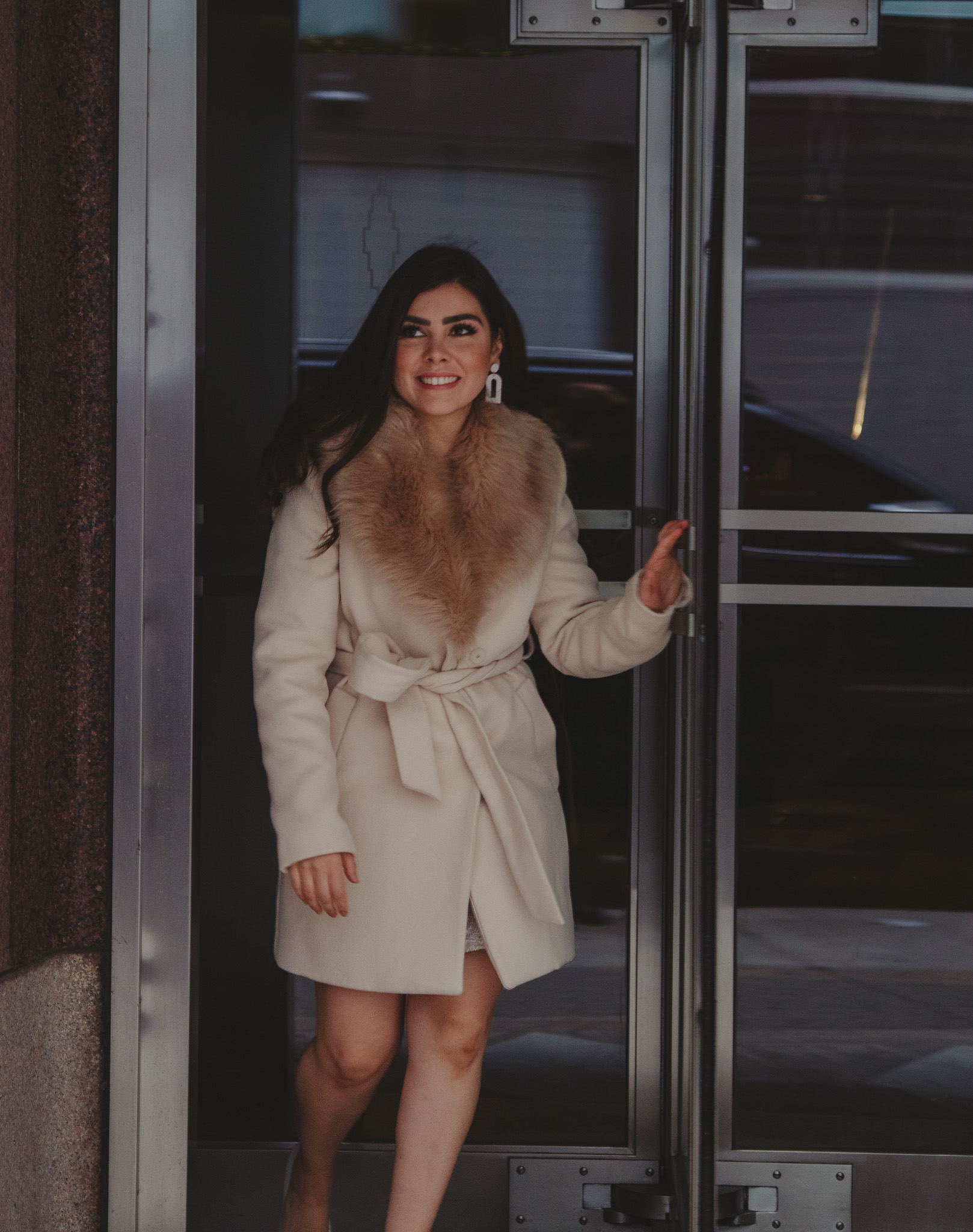 Female leaving out of rotating doors during lifestyle branding photoshoot