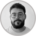 Portrait en noir et blanc d'un homme avec une barbe, moustache et des lunettes rondes.