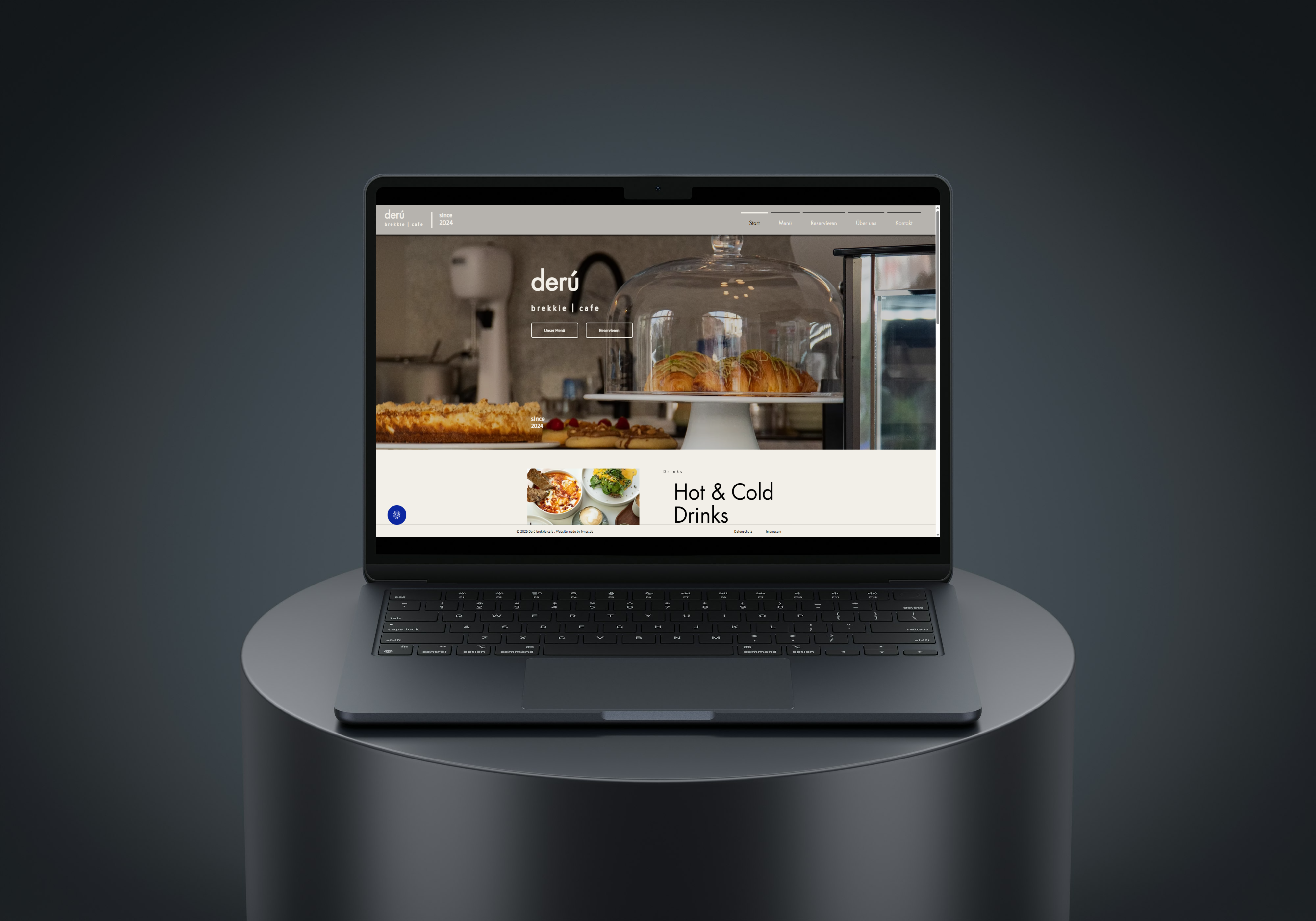 Laptop zeigt die Webseite eines Cafés namens derú brekkie | cafe mit Bildern von Gebäck und dem Text Hot & Cold Drinks.
