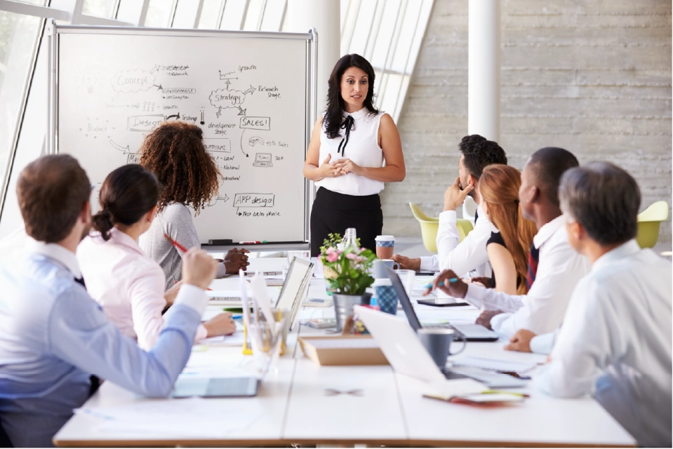 girl presenting using whiteboard to team members