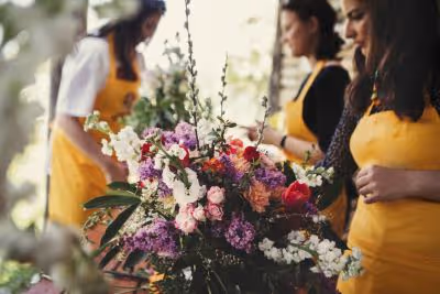 Femmes en tablier jaune qui préparent des bouquets dans un atelier