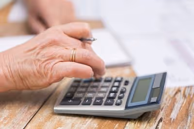 Zoom sur une main qui utilise une calculatrice