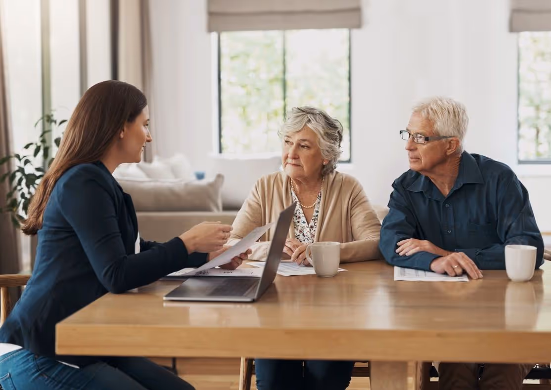 Conseillère funéraire qui discute avec un couple de senior, autour d'une table