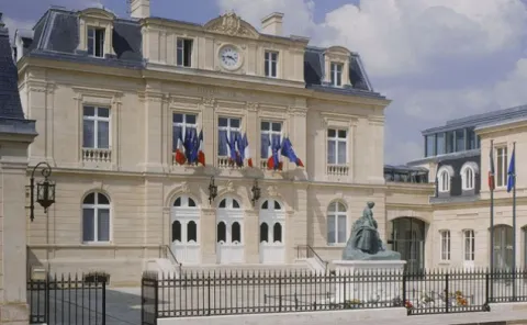 Conseillère funéraire qui discute avec un couple de senior, autour d'une table