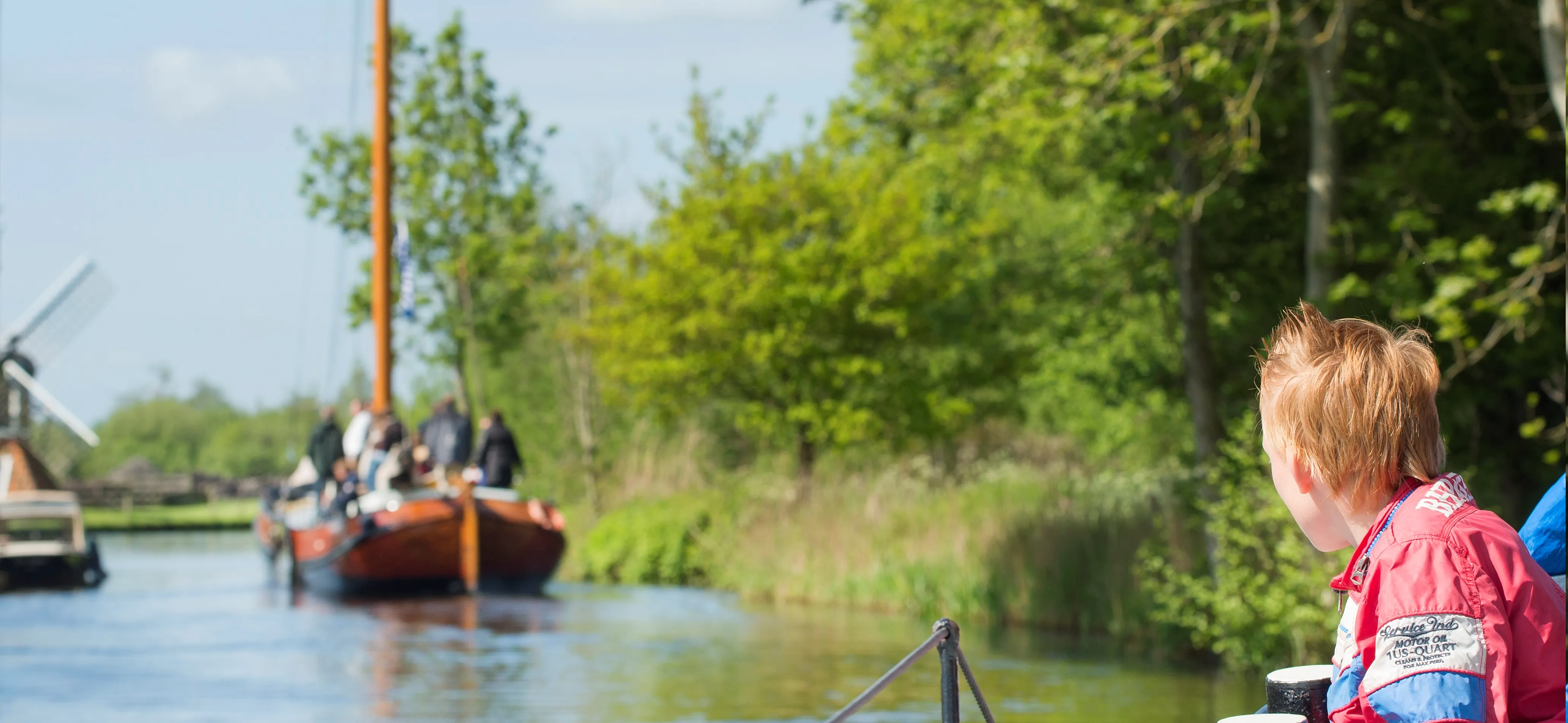 Kind kijkend naar boten op het water.