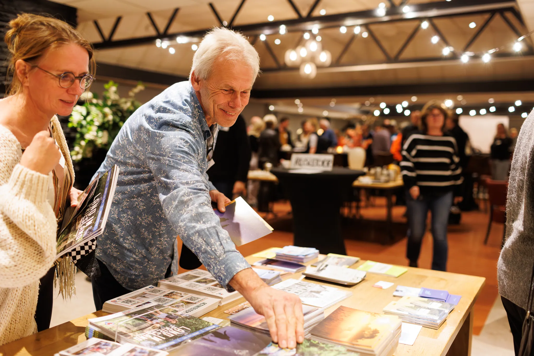 Gasten pakken folders bij Najaarsbijeenkomst 2024 van RMT NOF.