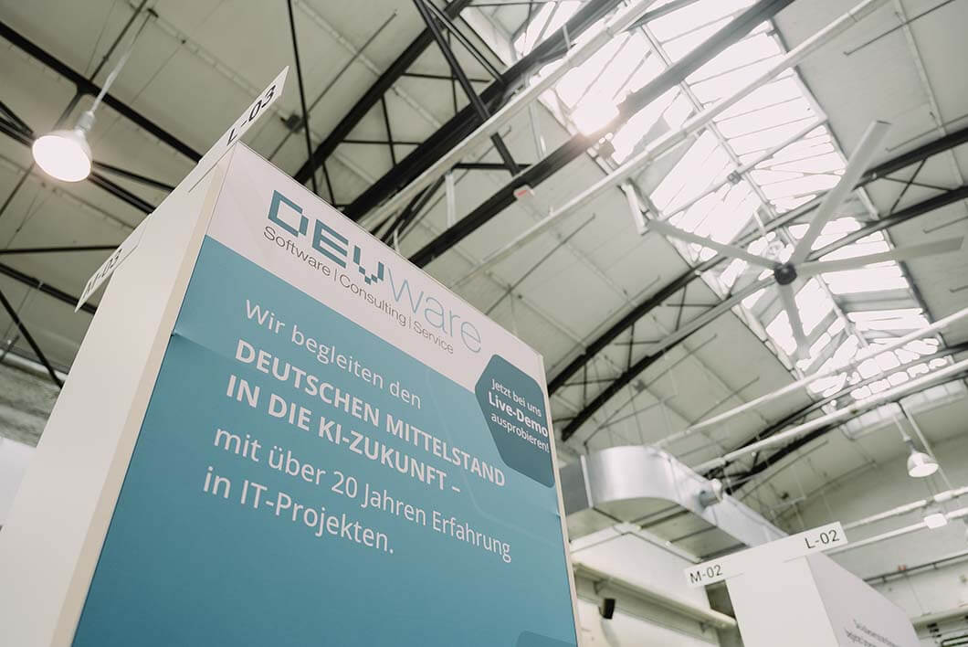 Messestand von devware mit Text zur Begleitung des deutschen Mittelstands in die KI-Zukunft und über 20 Jahren Erfahrung in IT-Projekten.