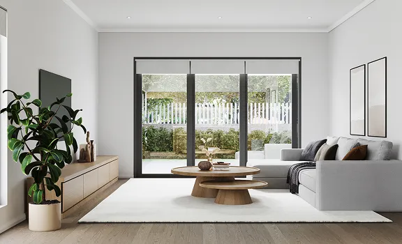 Modern living room with large glass sliding doors, a gray sectional sofa, white area rug, round wooden coffee tables, and a wooden media console with a flat-screen TV and decorative plants.