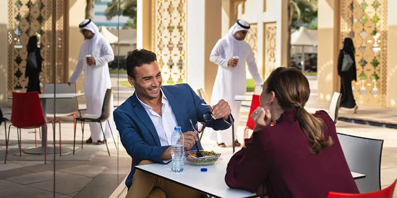 a couple enjoying food in a restauarant surrounded by arab people