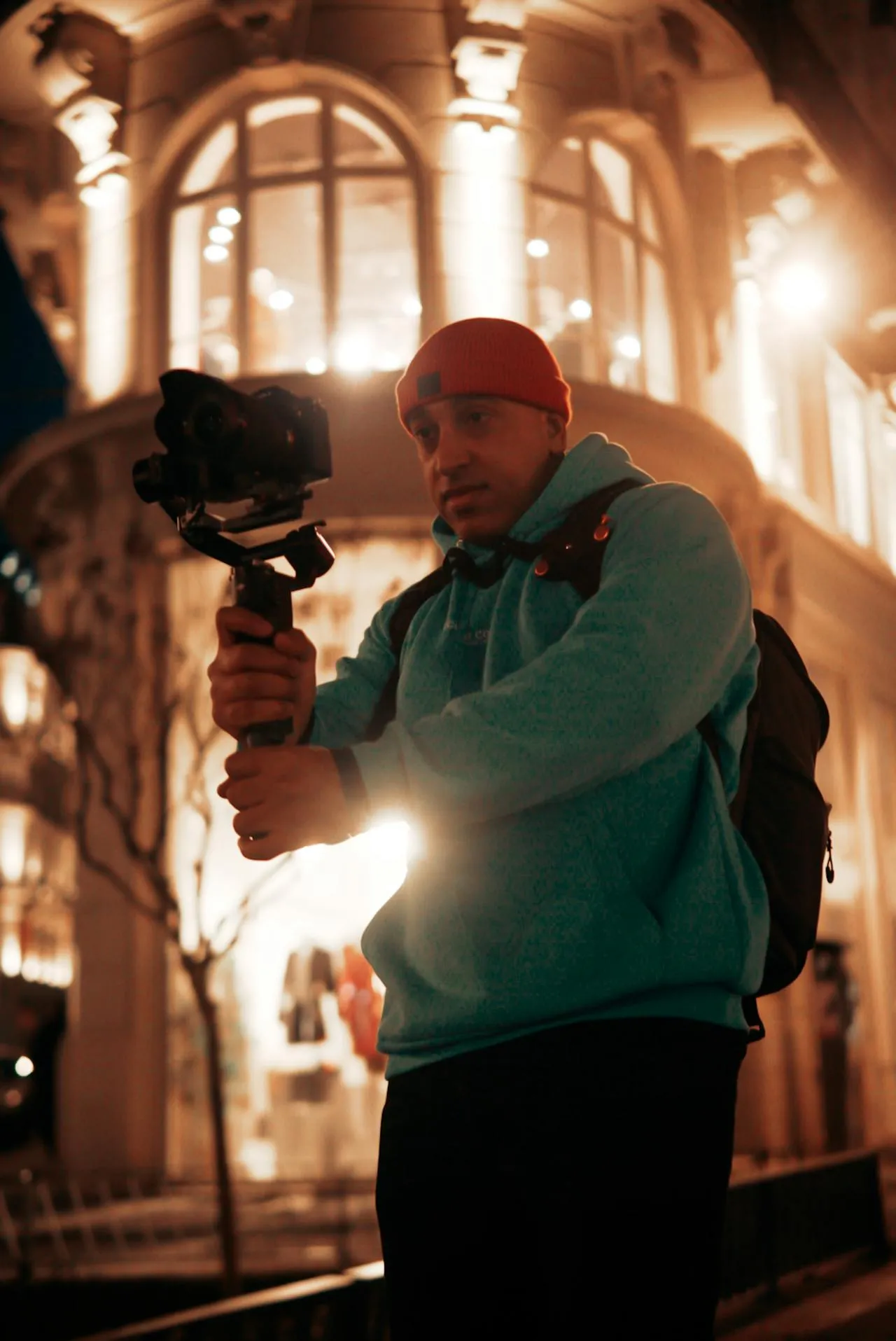 A man holding a camera in front of a building.