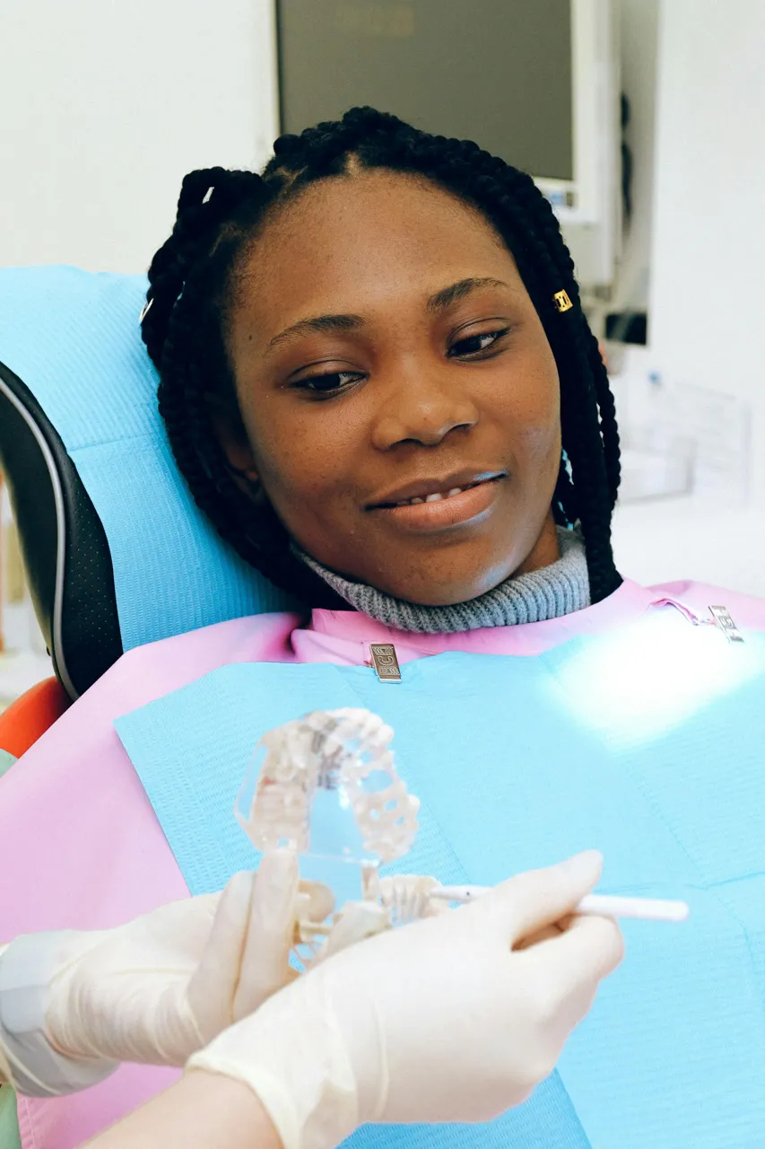 An image of a girl smiling at a tooth mould