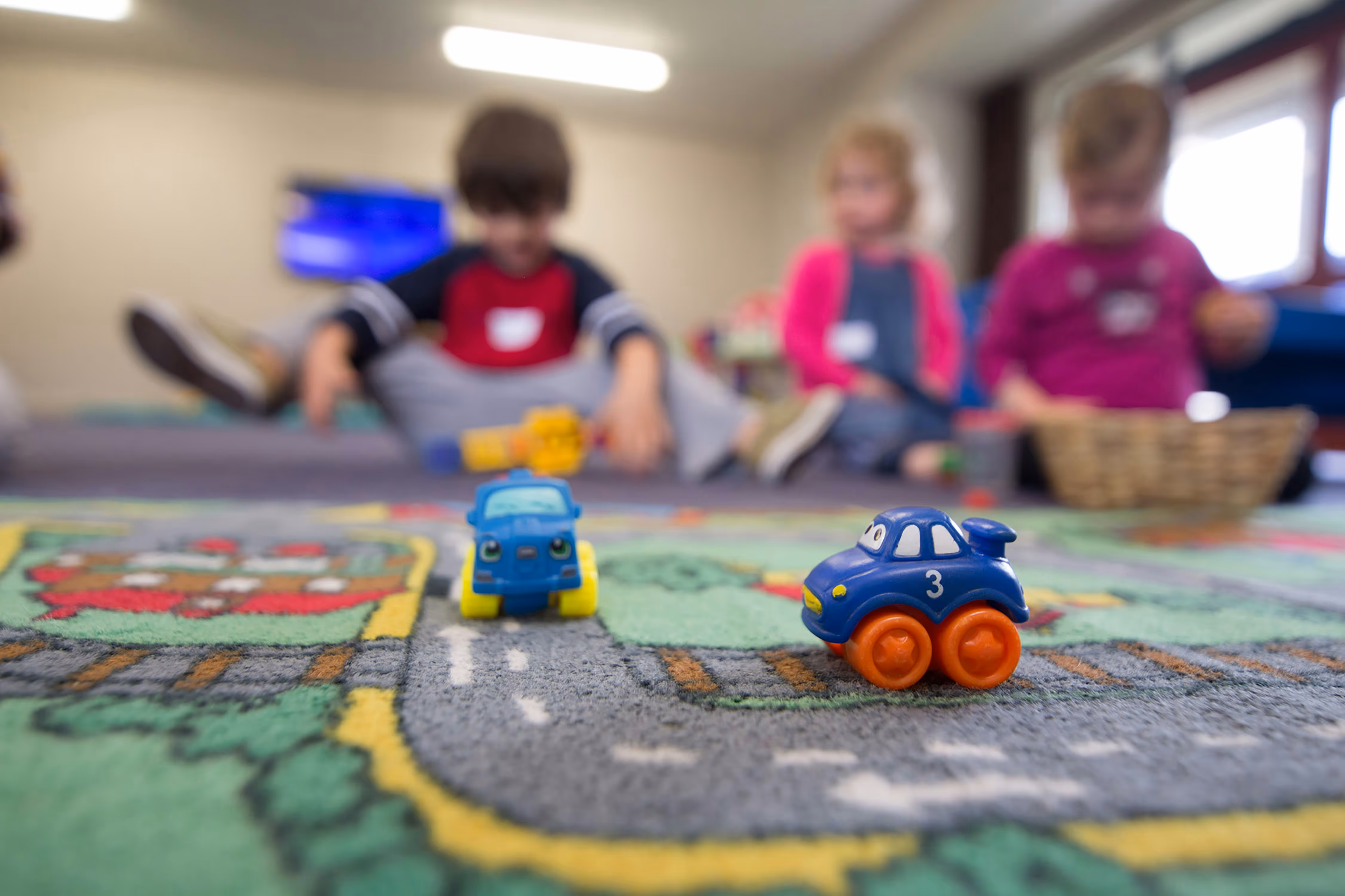 Een speelgoedkleed met kinderen spelend op het kleed. 