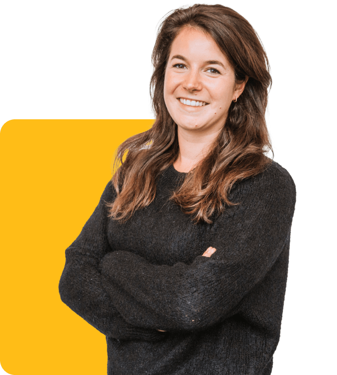 Portrait of a smiling professional woman standing with arms crossed against a clean, geometric background. Her confident posture and friendly expression convey leadership, approachability, and professionalism—ideal for use in corporate bios, team pages, or business branding.