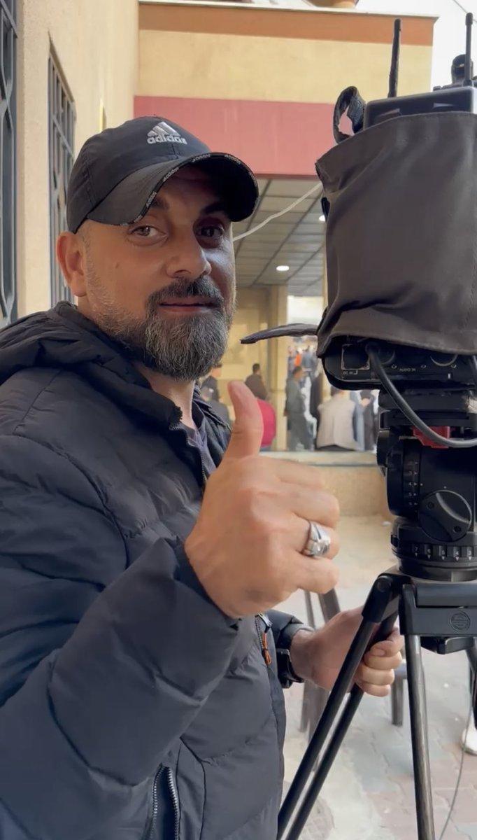 A person with a hat and a cameraDescription automatically generated