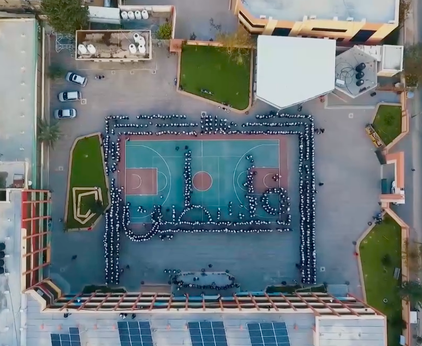 A basketball court with people around itDescription automatically generated