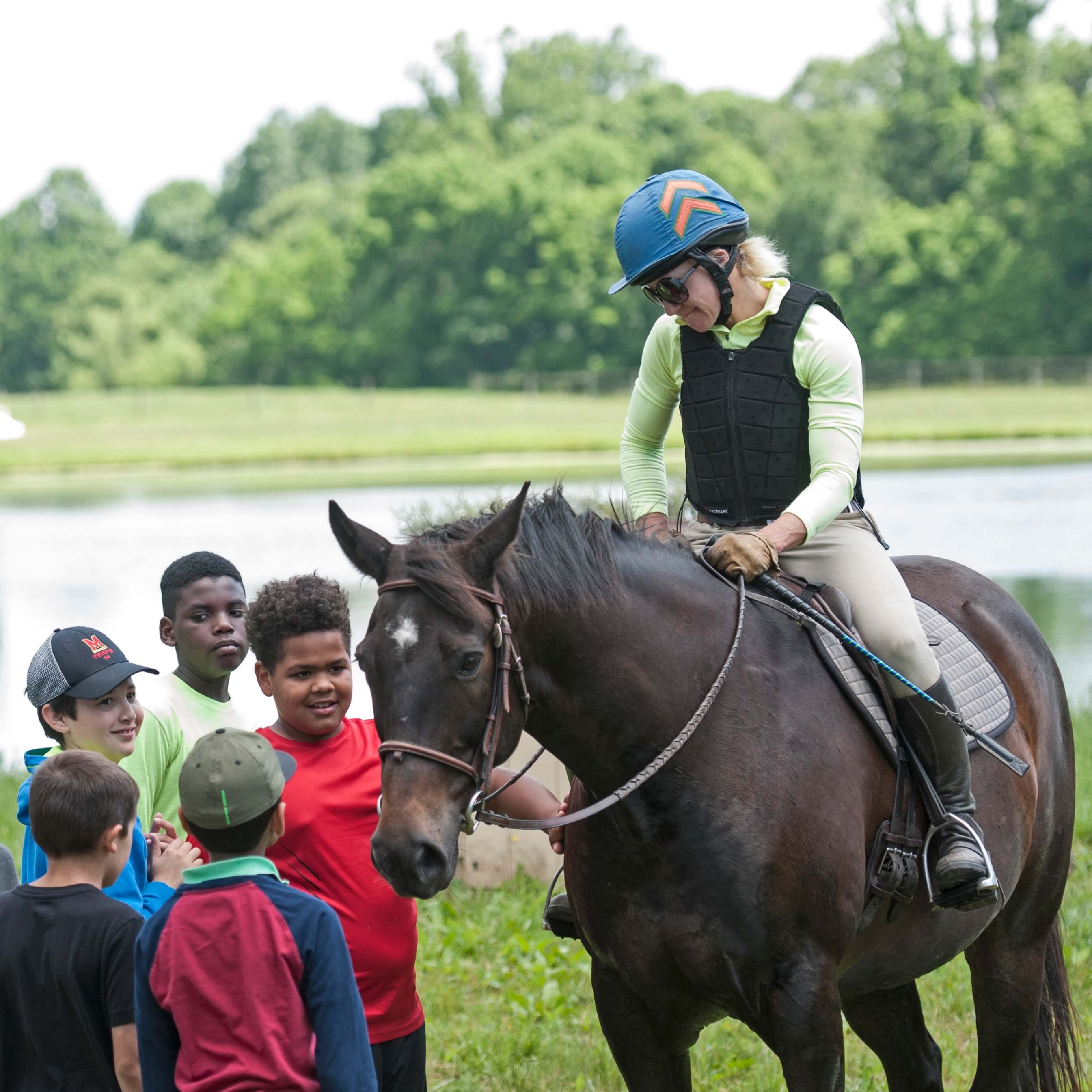 Women horse rider showing kids the horse