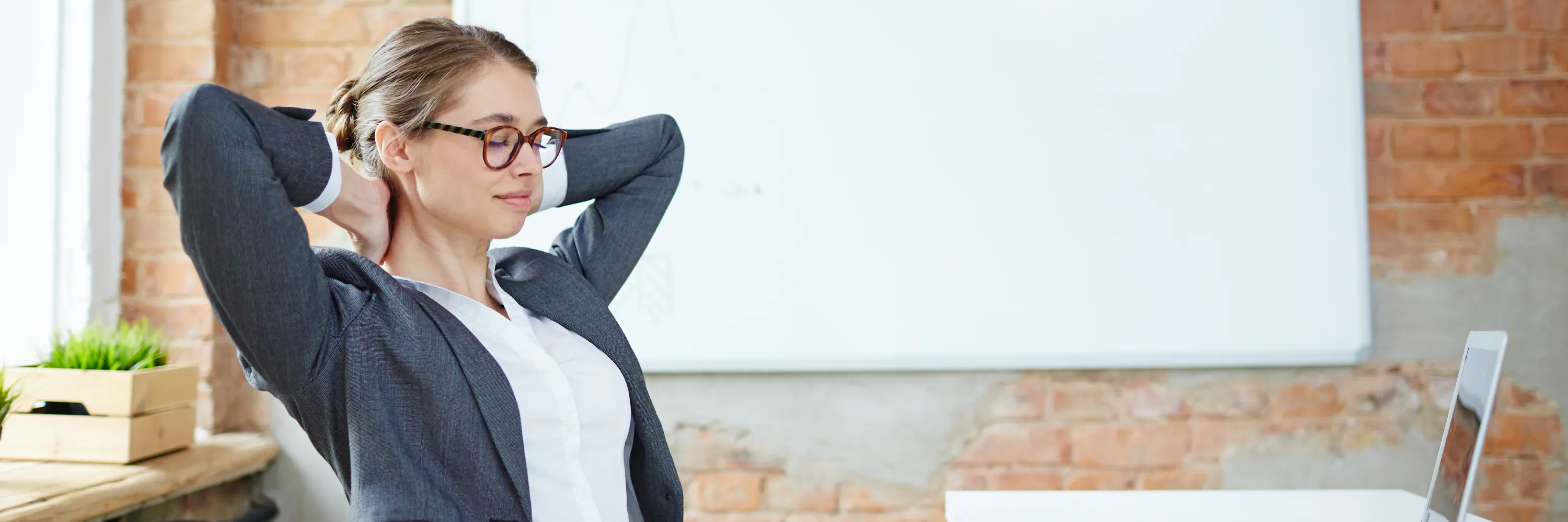 Professional office worker performing upper body stretching and posture exercises at modern desk workspace, demonstrating essential movement strategies for office workers to improve workplace ergonomics