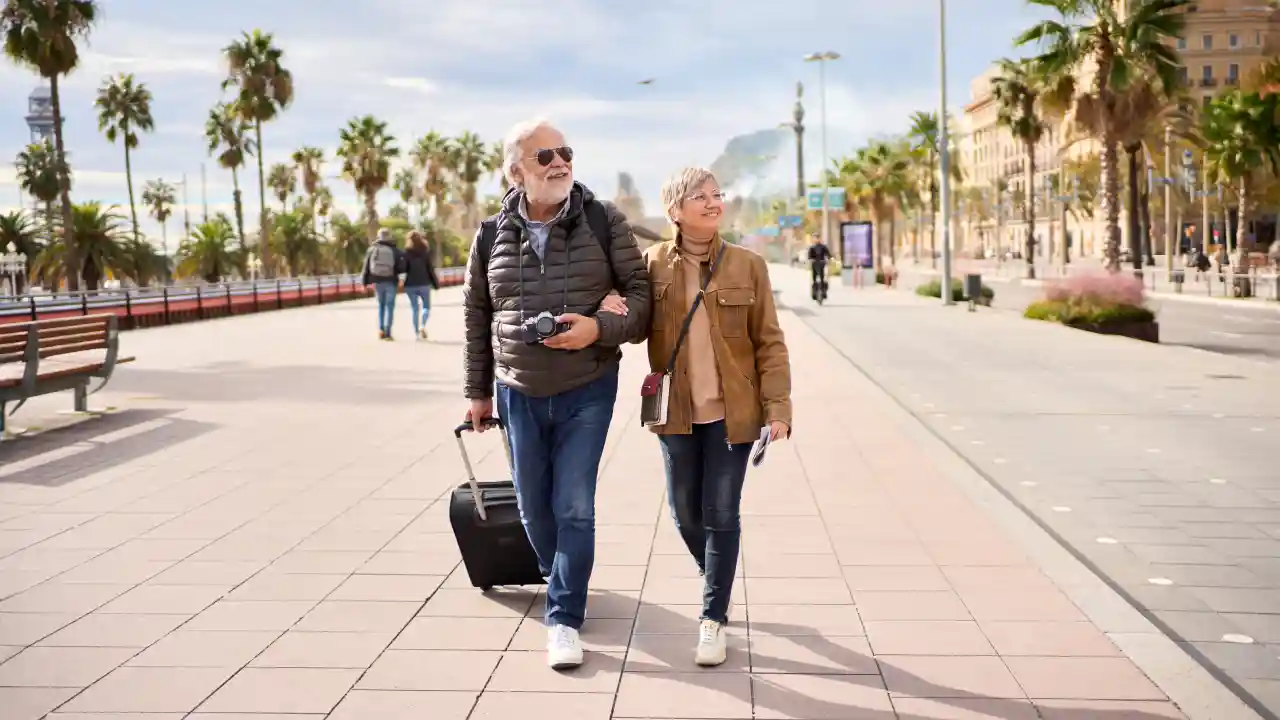 Travelers walking with suitcase and camera, showing how vacation prep supports staying comfortable and mobile on your feet
