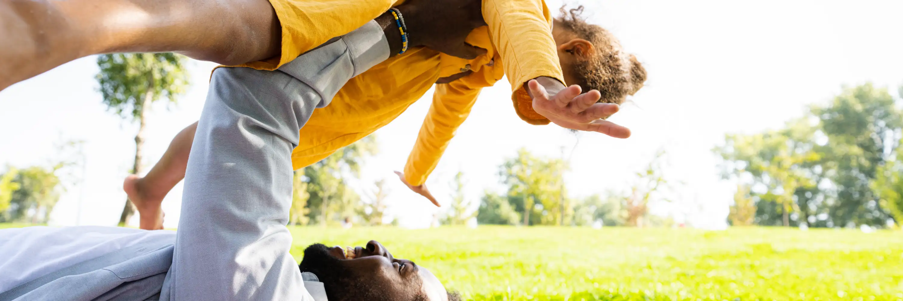 Parent and child playing outdoors, exploring balance through joyful movement—highlighting playful ways to build coordination and confidence in kids
