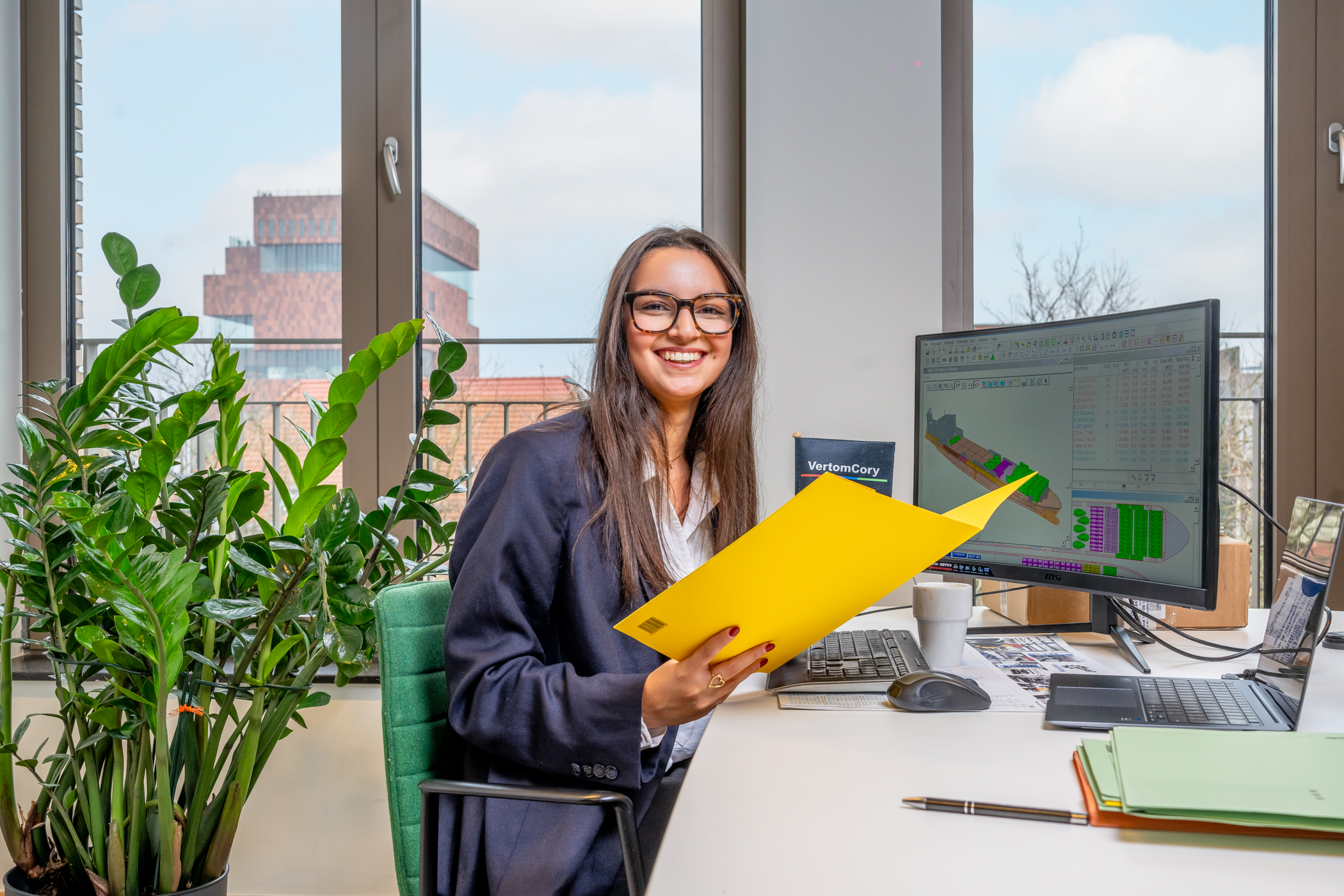 Medewerker aan bureau met documenten en computerscherm