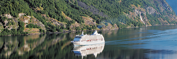 Cruise ship sailing through a green fjord