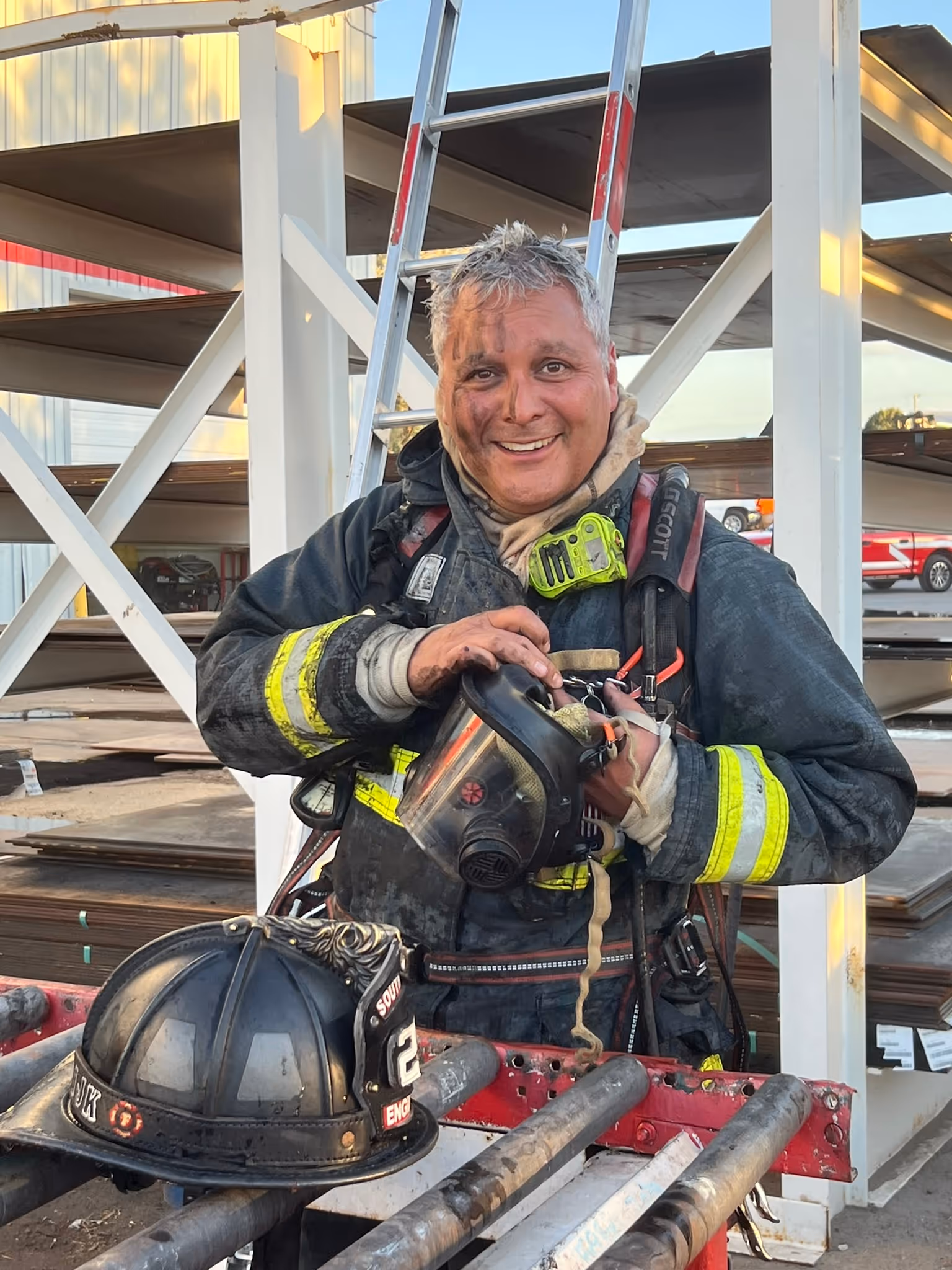 A firefighter in full uniform smiling 
