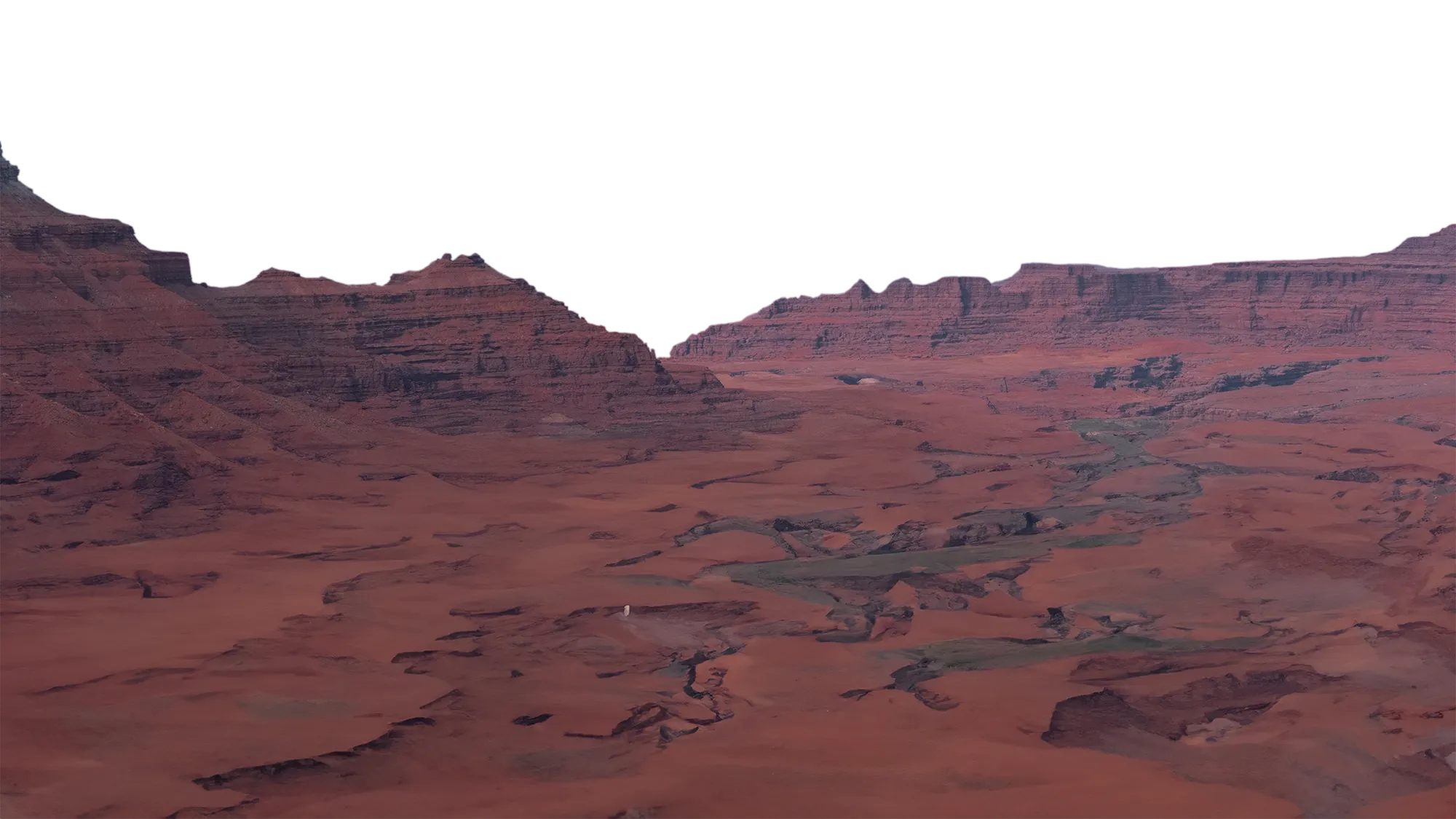 Expansive desert canyon landscape with layered red rock cliffs under a clear sky at dusk.